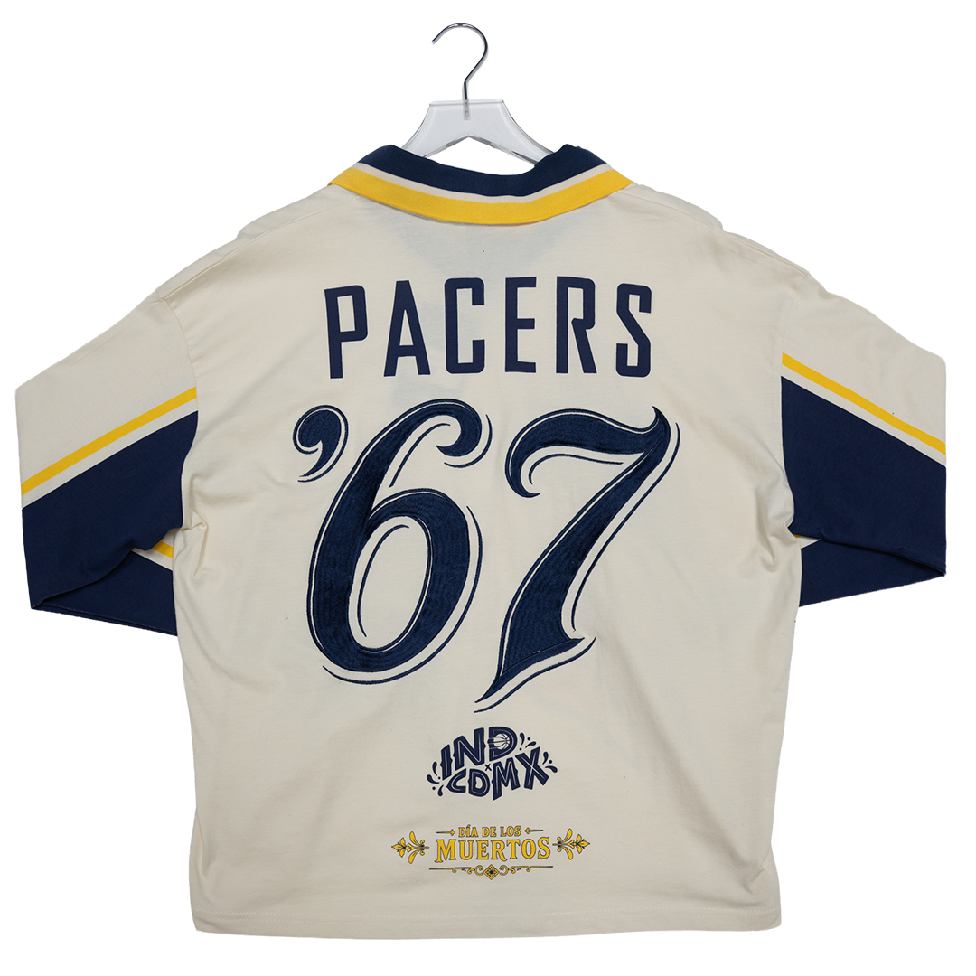 Back view of a cream-colored sports jersey hanging on a hanger, featuring navy blue and yellow accents, the word &