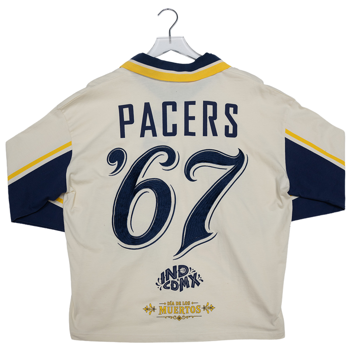 Back view of a cream-colored sports jersey hanging on a hanger, featuring navy blue and yellow accents, the word &