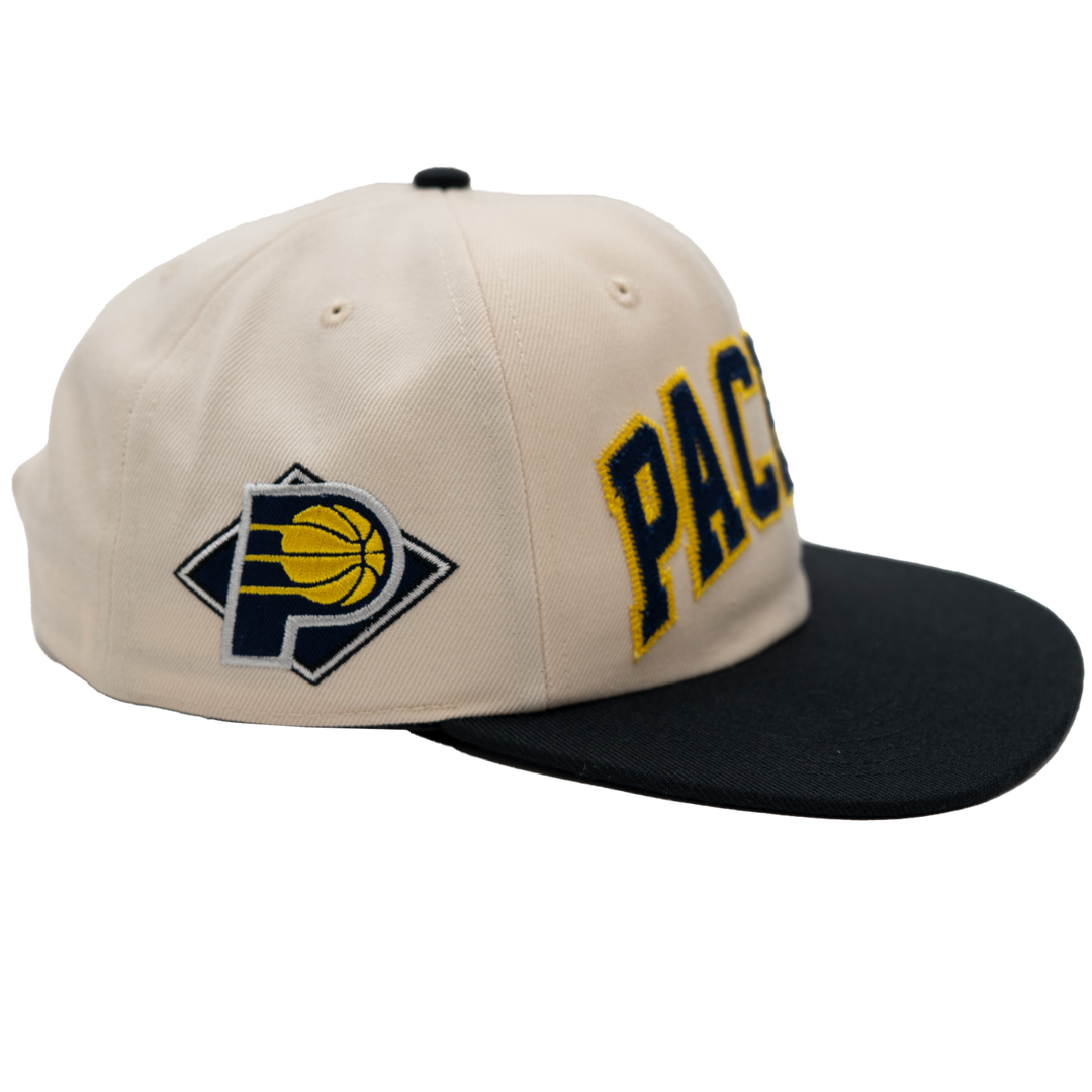 Beige and black cap with Pacers logo on a white background