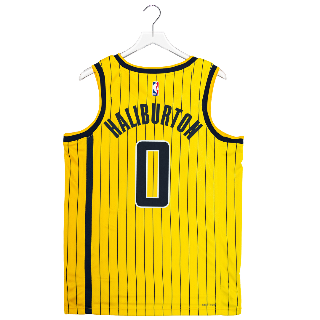 A yellow and black pinstriped basketball jersey shown from the back on a white hanger against a white background. The jersey features the name 'HALIBURTON' and the number '0' in black with a white outline, and an NBA logo is visible at the upper back.