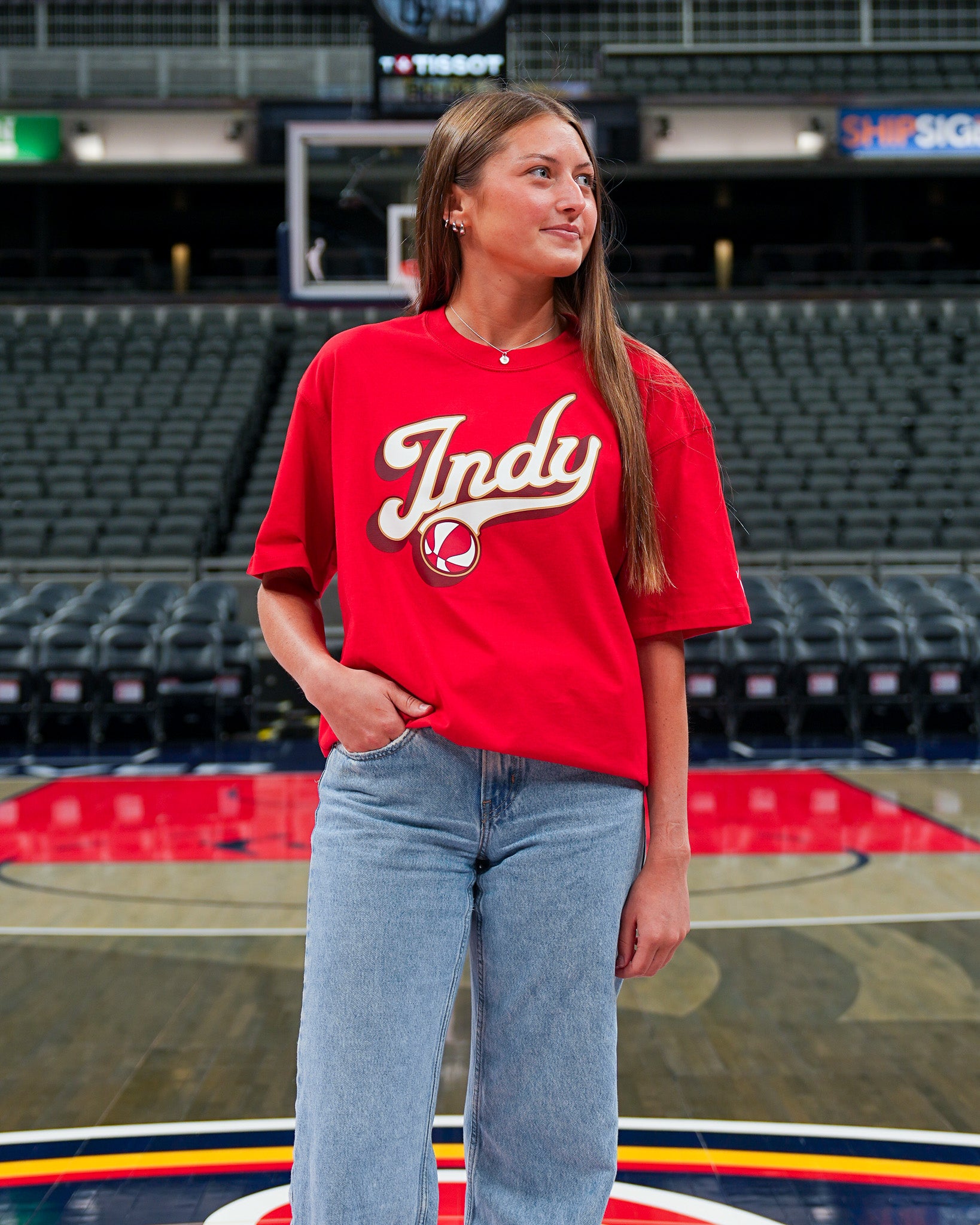 Person wearing a red 'Indy' t-shirt in an indoor sports arena.
