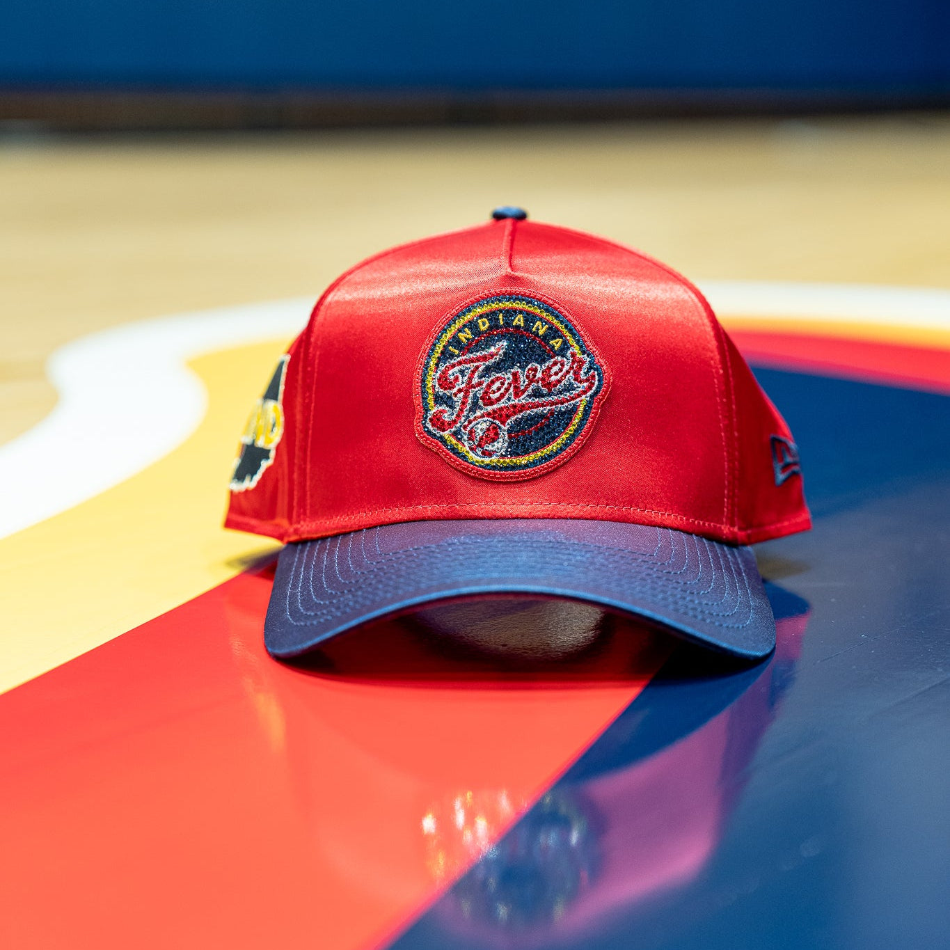 Red and blue cap with a logo on a colorful surface